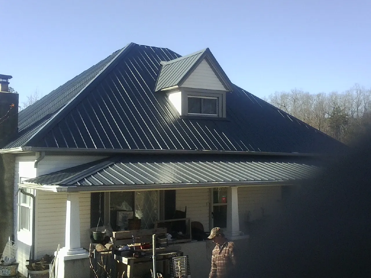 Dark blue standing seam metal roof with a dormer above a front porch in Circleville