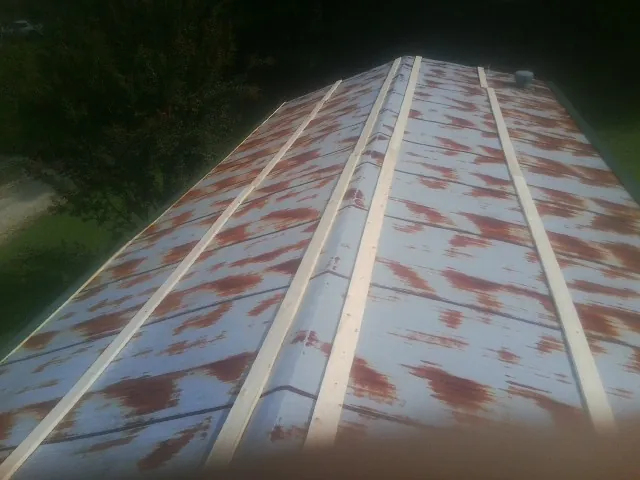 Rusted metal roof panels with new wood purlins before replacement — Storm Damage Roof Repair in Circleville by Roofing Brothers